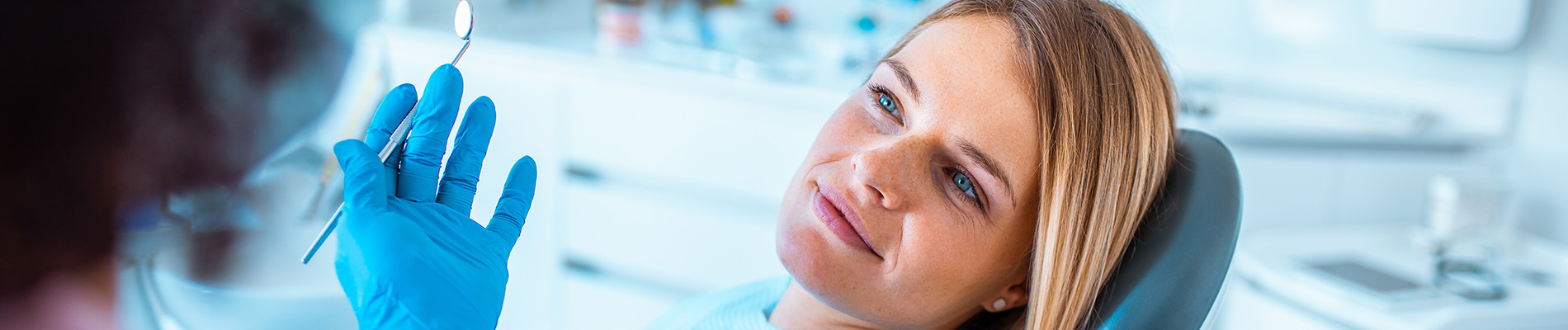 A well-lit reception area with a desk, computer monitor, and potted plant.